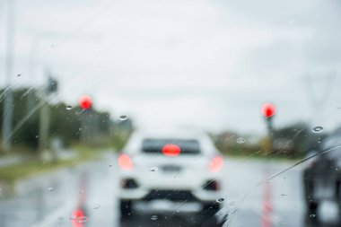 Avustralya 'da ön camdan yağmurun bulanık odaklı görüntüsü. Yol arkaplanındaki yağmur