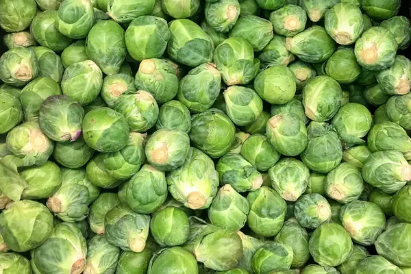 ブリュッセルの芽が市場の屋台に積み上げられました 緑の野菜の背景 — ストック写真