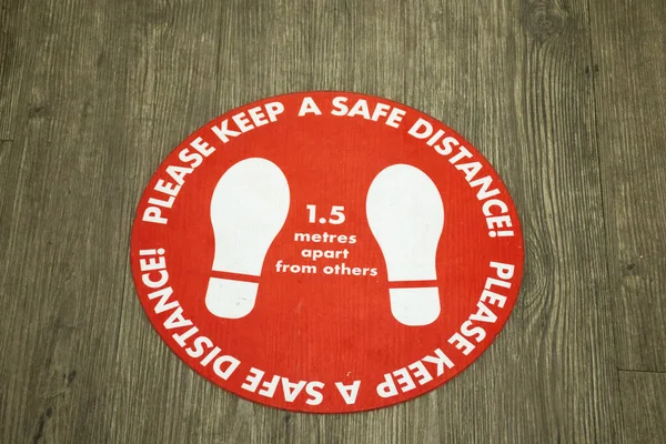 COVID-19. Sticker on the floor about social distancing. Please keep a safe distance. 1.5 metres apart from others.