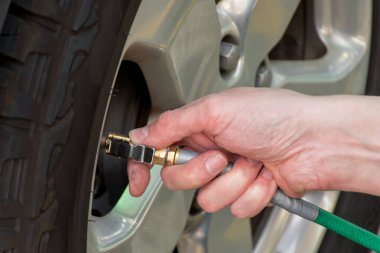 El tutuş basınç göstergesi, hava basıncını ölçmek ve arabanın lastiklerini doldurmak. Araba bakımı. Seyahatten önce lastik hava basıncı kontrol ediliyor.