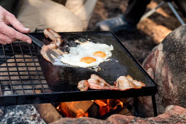 Ontbijtkamp Koken Grillen Van Knapperig Spek Eieren Een Gietijzeren Plaat — Stockfoto