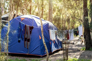 Tatil parkının çevresindeki kamp alanında geniş bir çadır kurulmuş. Giysiler ve dalış giysileri kumaş bir çizgide kuruyor.