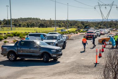 Barden Ridge, Avustralya - 2021-07-18 Tıbbi malzeme COVID-19 test kliniğinde test sürüşü yapıyor. Uzun araç kuyruğu.