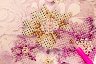 Elmas işlemeli kumaş. Akrilik elmaslar ve kalem aleti. Yakın çekim, seçici odaklanma