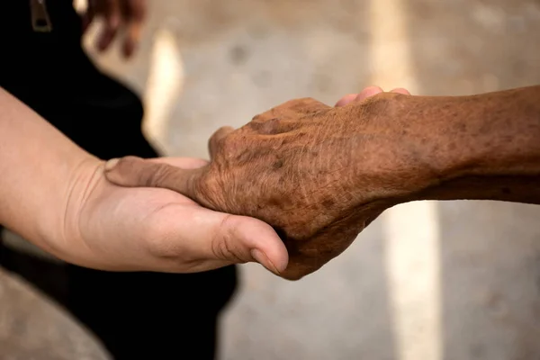 Młoda Kobieta Trzymająca Rękę Starszą Osobę — Zdjęcie stockowe