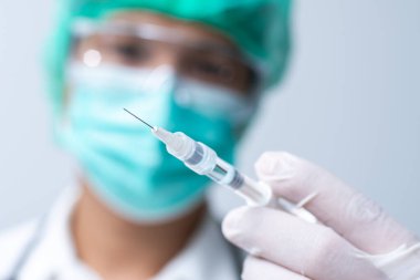 Doktor yüz maskesi takıyor ve şırınga hazırlayan beyaz tıbbi eldiven kullanıyor. Covid-19 virüs kavramına karşı aşı.
