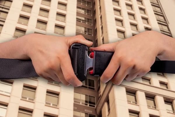 Het concept van veilige gebouw, close-up twee hand gebruik veiligheidsgordel op gebouw achtergrond wazig — Stockfoto