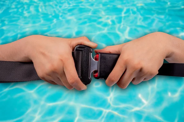 Safe water concept, close up two hand use safety belt on water  blur  background