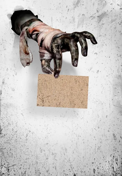 Zombie hand holding a  brown paper on white .Halloween concept — Stock Photo, Image