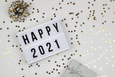 Mutlu 2021 kelimeleri, hediye kutusu ve beyaz arka planda tatil konfetisi. Üst Manzara. Yeni yıl kutlaması. Mutlu yıllar 2021 konsepti. 