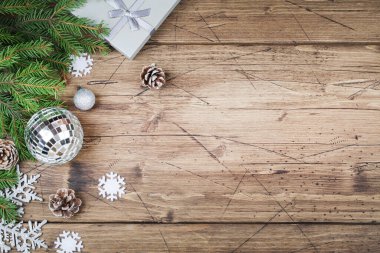 Köknar dalları, hediye konileri, kar taneleri ve kahverengi ahşap arka planda disko topları, üst görünüm kopyalama alanı. Noel ve Yeni Yıl geçmişi