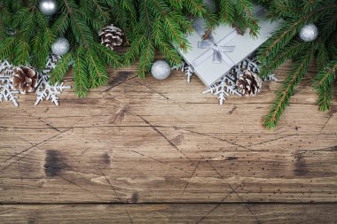 Köknar dalları, hediyeler, koniler, kar taneleri ve kahverengi ahşap arka plandaki toplar, en üstteki düz görünüm kopya alanı. Noel ve Yeni Yıl geçmişi