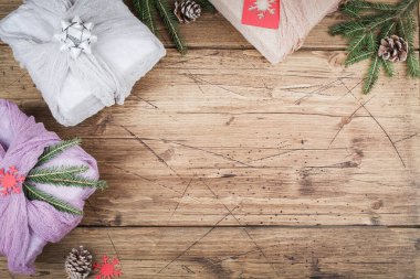 Noel ve sıfır atık, çevre dostu ambalaj. Kumaş, kahverengi ahşap masaya hediyeler, ekolojik Noel tatili konsepti, ekolojik dekor