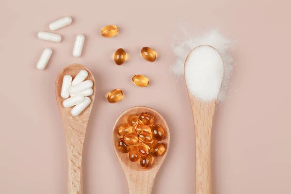Supplements for health , vitamin D zinc and vitamin C powder in wooden spoons on beige background. top view .healthy lifestyle concept.
