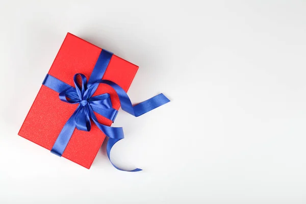 Rood cadeau of geschenkdoos met blauw lint op witte achtergrond. — Stockfoto