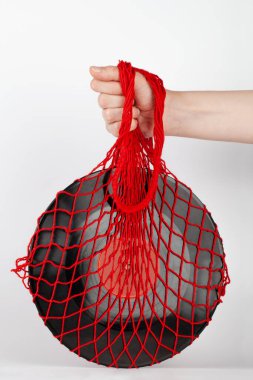 Yeniden kullanılabilir çevre dostu bir alışveriş çantasıyla elinde müzik tabağı olan bir kadın. Eski konsept