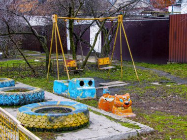 Çocuğu olmayan boş bir oyun parkı. Eski, terk edilmiş, salıncaklı oyun parkı. COVID-19 salgınının sonuçları. Tecrit altındaki çocuklar.