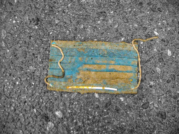 Pavement 'e atılmış tıbbi maske. Coronavirus 'un sonu. İnsanlar halka açık bir sokakta cerrahi koruyucu yüz maskesi takmaz. COVID-19 salgınından sonra çevre kirliliği kavramı.