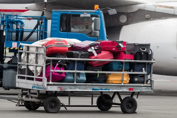Carrinho de bagagem na pista do aeroporto Macedônia um dia chuvoso — Fotografia de Stock