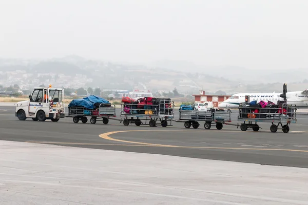 Luggage cart on the runway of the airport Macedonia a rainy day — Stock Photo, Image