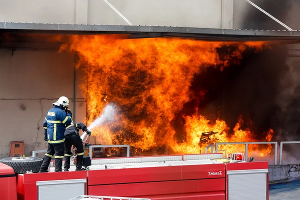 Hasiči se snaží uhasit požár, který vypukl v — Stock fotografie