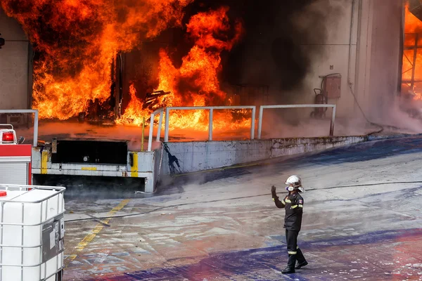 Brandweerlieden worstelen om te blussen van de brand brak uit op een — Stockfoto