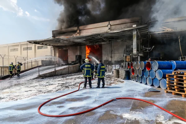 Brandmän kämpar för att släcka den eld som bröt ut vid en — Stockfoto