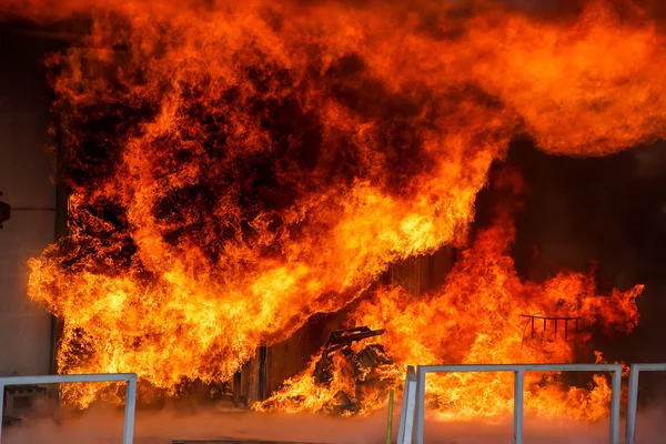 Brandweerlieden worstelen om te blussen van de brand brak uit op een — Stockfoto