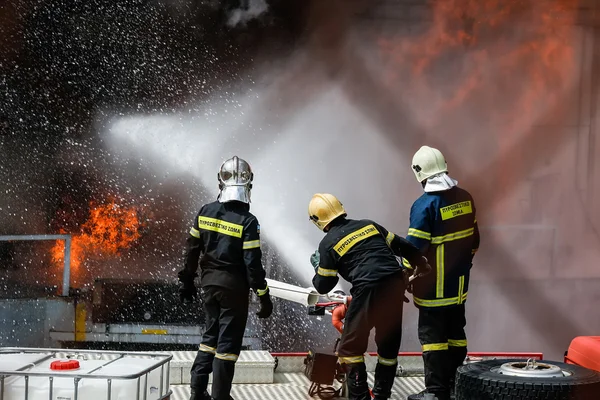 Hasiči se snaží uhasit požár, který vypukl v — Stock fotografie