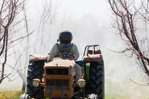 Agricoltore con trattore con spruzzatore ad aria compressa — Foto Stock