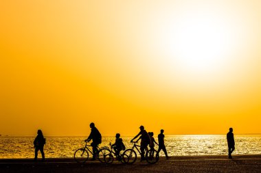 Bir yürüyüş kasaba deniz tarafından zevk insan siluetleri