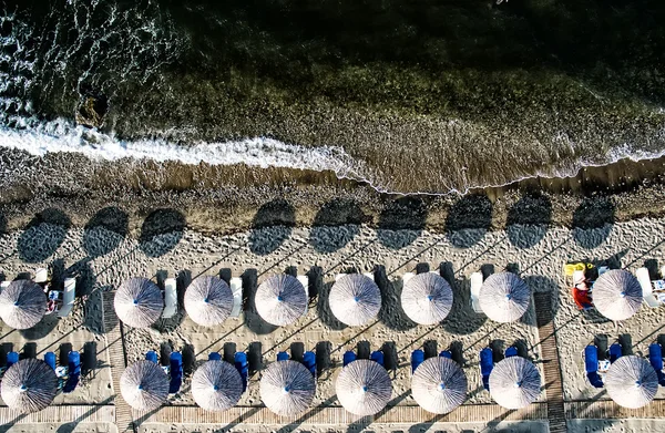Вид сверху на пляж с сандалиями и пумбреллами — стоковое фото