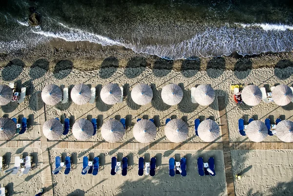 Tampilan atas pantai dengan tempat tidur matahari dan payung — Stok Foto