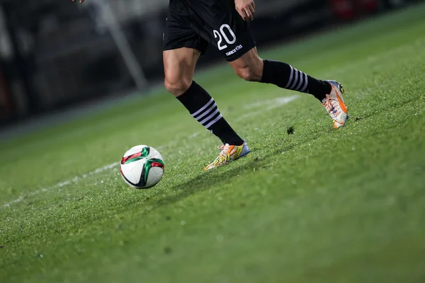 Мяч и ноги футболиста — стоковое фото