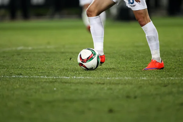 Bola e um pé de um jogador de futebol — Fotografia de Stock