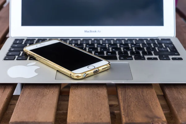 Laptop and phone apple on a wooden table — Stock Photo, Image