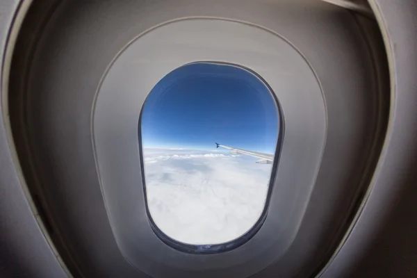 Ventana del avión con ala y cielo nublado detrás . — Foto de Stock