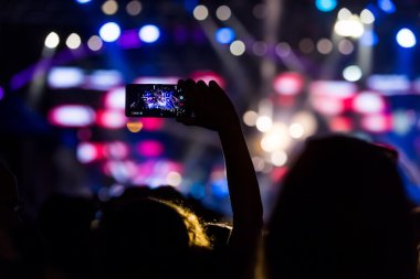 Bir müzik sırasında dokunmatik akıllı telefon ile fotoğraf çekmeye kişi 