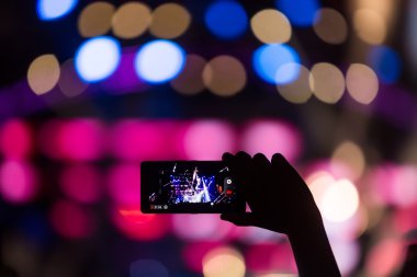 Bir müzik sırasında dokunmatik akıllı telefon ile fotoğraf çekmeye kişi 