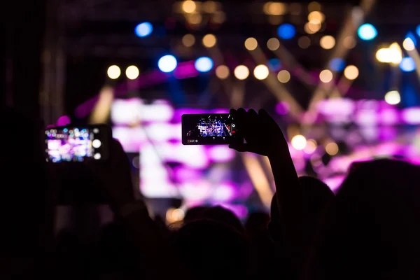 Personas que toman fotografías con un teléfono inteligente táctil durante una música —  Fotos de Stock