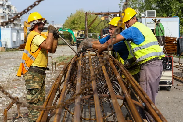 Lavoratori non identificati che lavorano con ferro calcestruzzo in una costruzione — Foto Stock