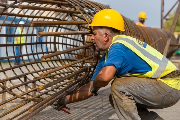 Lavoratori non identificati che lavorano con ferro calcestruzzo in una costruzione — Foto Stock