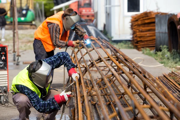 Lavoratori non identificati che lavorano con ferro calcestruzzo in una costruzione — Foto Stock