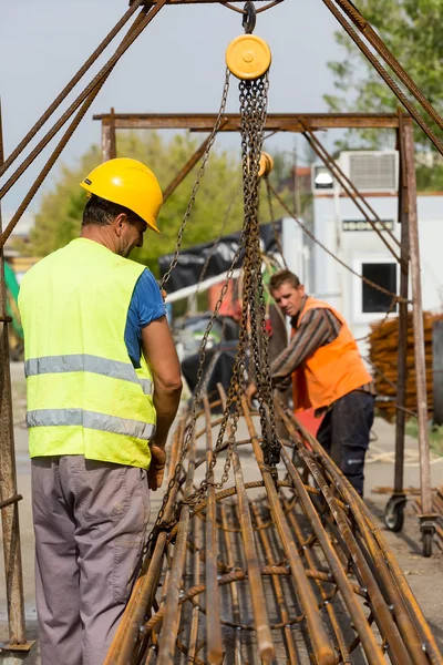 Lavoratori non identificati che lavorano con ferro calcestruzzo in una costruzione — Foto Stock