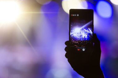 Bir müzik sırasında dokunmatik akıllı telefon ile fotoğraf çekmeye kişi 