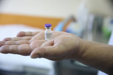 Selanik, Yunanistan - 29 Aralık 2020: Bir hemşire, AHEPA ulusal aşılarına başlarken AHEPA hastanesinde Pfizer-BioNTech Coronavirus hastalığından (COVID-19) bir şişe taşıyor 