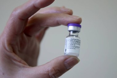 Selanik, Yunanistan - 29 Aralık 2020: Bir hemşire, AHEPA ulusal aşılarına başlarken AHEPA hastanesinde Pfizer-BioNTech Coronavirus hastalığından (COVID-19) bir şişe taşıyor 