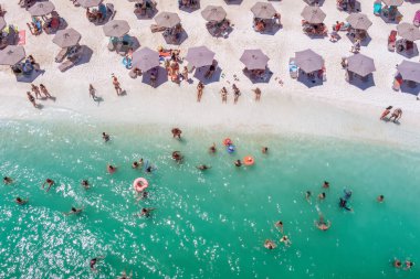 Mermer plaj, Thassos adası, Yunanistan - 19 Temmuz 2021: Yukarıdan bakıldığında, plaj şemsiyeleri ve yüzen ve dinlenen turistlerle dolu beyaz plajlı bir zümrüt ve saydam Akdeniz manzarası.