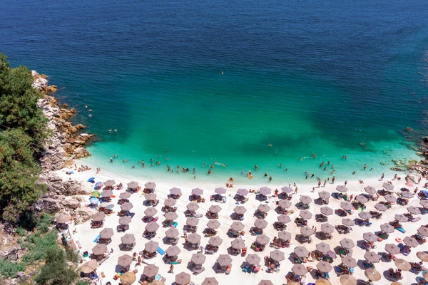 Yukarıdan bakıldığında, zümrüt ve şeffaf bir Akdeniz manzarası, plaj şemsiyeleri ve dinlenip yüzen turistlerle dolu beyaz bir plaj. Mermer plaj, Thassos Adası, Yunanistan.