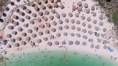 Mermer plaj, Thassos adası, Yunanistan - 19 Temmuz 2021: Yukarıdan bakıldığında, plaj şemsiyeleri ve yüzen ve dinlenen turistlerle dolu beyaz plajlı bir zümrüt ve saydam Akdeniz manzarası.